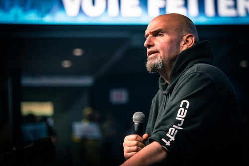 Man speaking into microphone on stage.