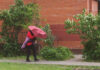 Person walking with a red umbrella in an urban area
