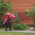 Person walking with a red umbrella in an urban area