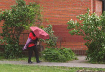 Person walking with a red umbrella in an urban area
