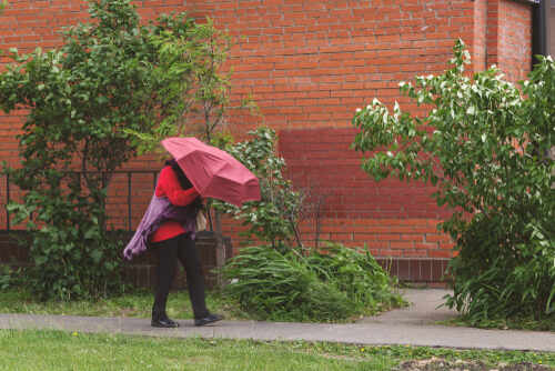 Person walking with a red umbrella in an urban area