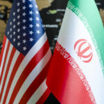 Iran Denies Talks: U.S. Strategy Questioned Flags of the United States and Iran displayed together