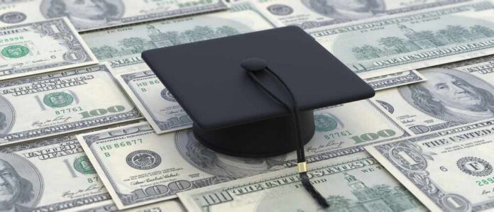 shutterstock_2088700669.jpg A graduation cap placed on a pile of hundred dollar bills