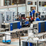 Airport security checkpoint with travelers and TSA agents