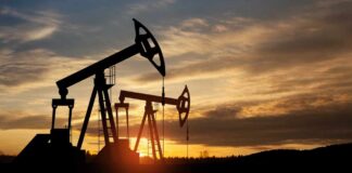 Silhouetted oil pumps against a colorful sunset sky