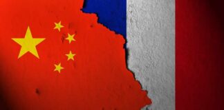 A textured wall displaying the flags of China and France