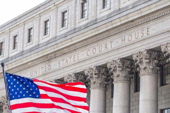Facade of a United States courthouse with an American flag in the foreground