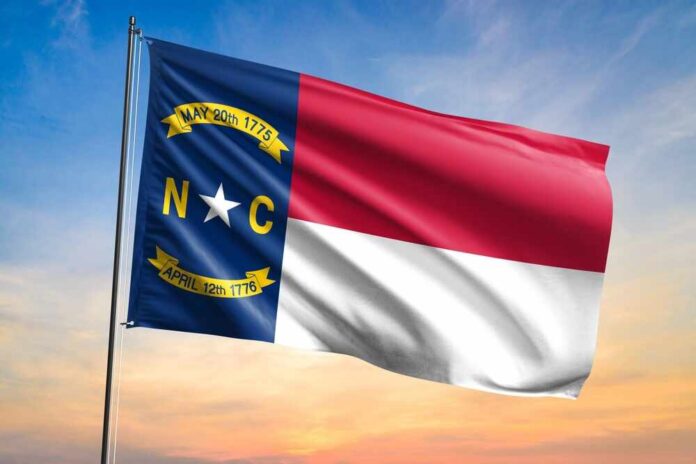 North Carolina state flag waving against a sunset sky