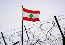 Massive Israeli Invasion: 800 Dead in Lebanon Lebanese flag waving next to barbed wire fence