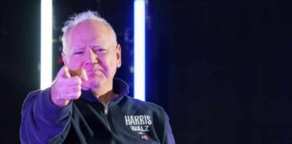 A person pointing confidently at the camera with a serious expression