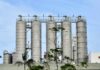 Metal storage silos at an industrial facility against a blue sky