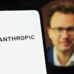 Pentagon BLACKLISTS AI Firm — Stunning Retaliation Close-up of a smartphone displaying the word 'ANTHROPIC' with a blurred portrait in the background