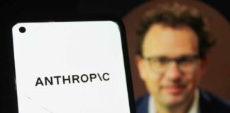 Close-up of a smartphone displaying the word 'ANTHROPIC' with a blurred portrait in the background