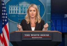 A government official speaking at a podium during a press briefing