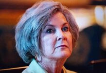 A mature woman with a serious expression in an indoor setting