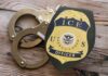 Federal-Sanctuary Clash: NYC Worker Detained ICE officer badge next to handcuffs on a wooden surface