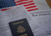 Passport and documents on table with American flag