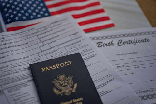 Passport and documents on table with American flag