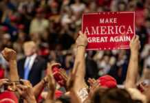 Crowd holding red Make America Great Again sign
