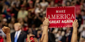 Crowd holding red Make America Great Again sign