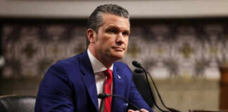 Man in blue suit speaking at a microphone