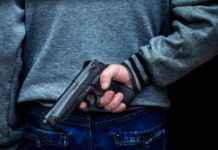 Person holding a handgun behind their back