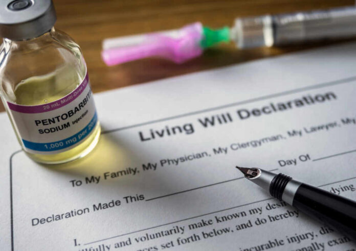 A vial of pentobarbital next to a living will declaration form and a fountain pen