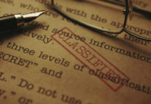 TOP SECRET Breach – Massive Risk to U.S. Security Close-up of a classified document with a pen and glasses