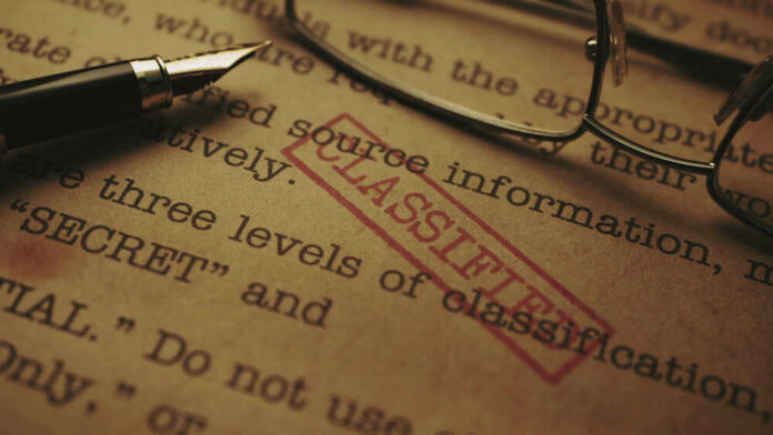 shutterstock_1948471972.jpg Close-up of a classified document with a pen and glasses