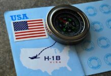 A compass placed on an H-1B visa document with a USA flag