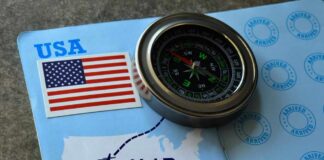 A compass placed on an H-1B visa document with a USA flag