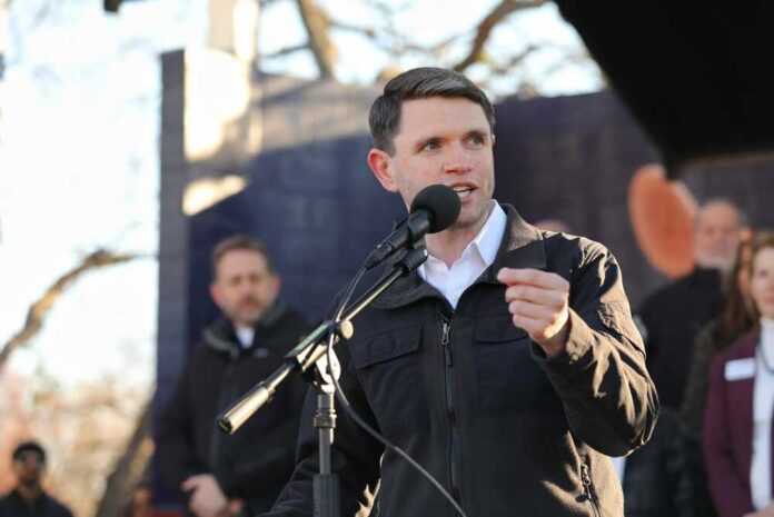 A speaker addressing an audience at an outdoor event with a microphone