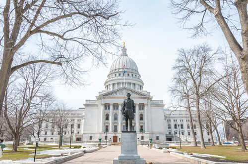 shutterstock_707564686 (1).jpg Statue in front of a grand state capitol building on a winter day