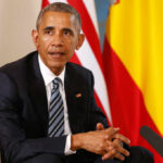 Photo Evidence: Obama Cozy With Communist Leader Man in a dark suit seated with flags in the background