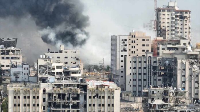 A view of destroyed buildings with smoke rising in the background