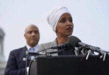Woman speaking at a podium with microphones