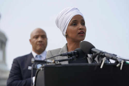 Woman speaking at a podium with microphones