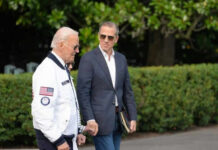Why Hunter’s Pardon Still Sparks Debate Two men walking outside near green bushes