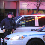 Brooklyn Address Haunted By Second Bloodshed Police officer standing near a crime scene with vehicles and caution tape