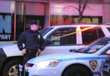 Brooklyn Address Haunted By Second Bloodshed Police officer standing near a crime scene with vehicles and caution tape