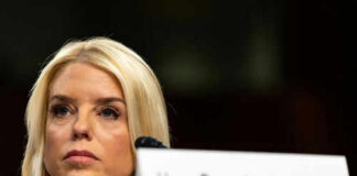 Woman sitting behind nameplate at conference or meeting
