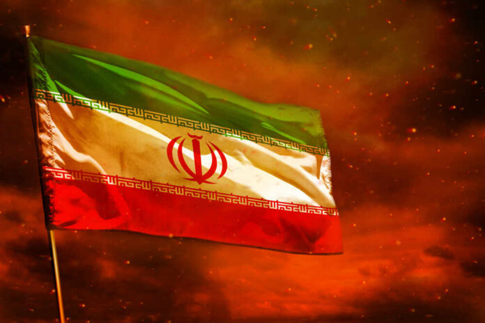 Fluttering,Iran,Flag,On,Crimson,Red,Sky,With,Smoke,Pillars Iranian flag waving against a dramatic orange sky