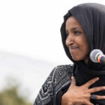 Democrats Block Ilhan Omar Subpoena – Shockwaves Hit Ilhan Omar speaking at a microphone during an event