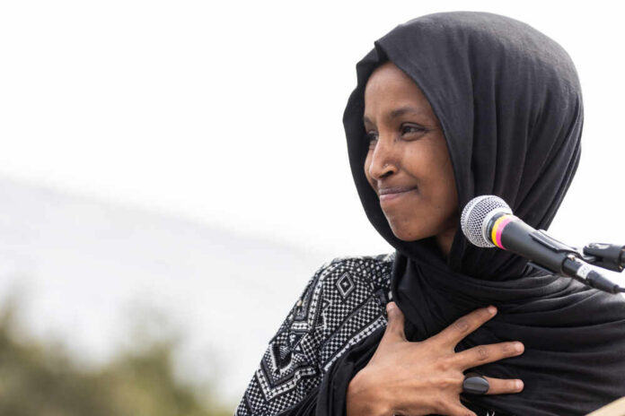 Ilhan Omar speaking at a microphone during an event