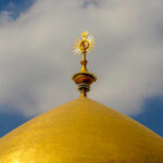 Assassination at Holy Site TRIGGERS International Firestorm Close-up of a golden dome with a decorative spire against a blue sky