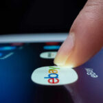 eBay Rejects GameStop’s $56B Offer—Too Risky! A finger tapping the eBay app icon on a smartphone screen
