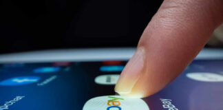 A finger tapping the eBay app icon on a smartphone screen