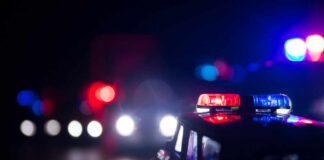 Close-up of a police car model with flashing lights in a dark setting