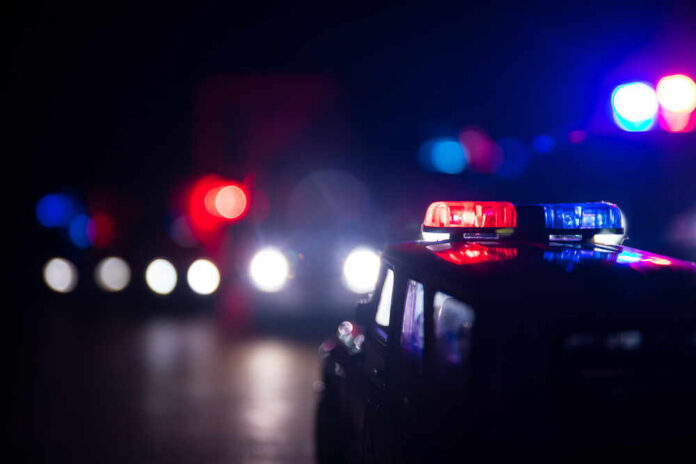 Close-up of a police car model with flashing lights in a dark setting