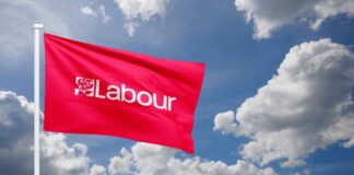 Red flag with 'Labour' text flying against a cloudy sky